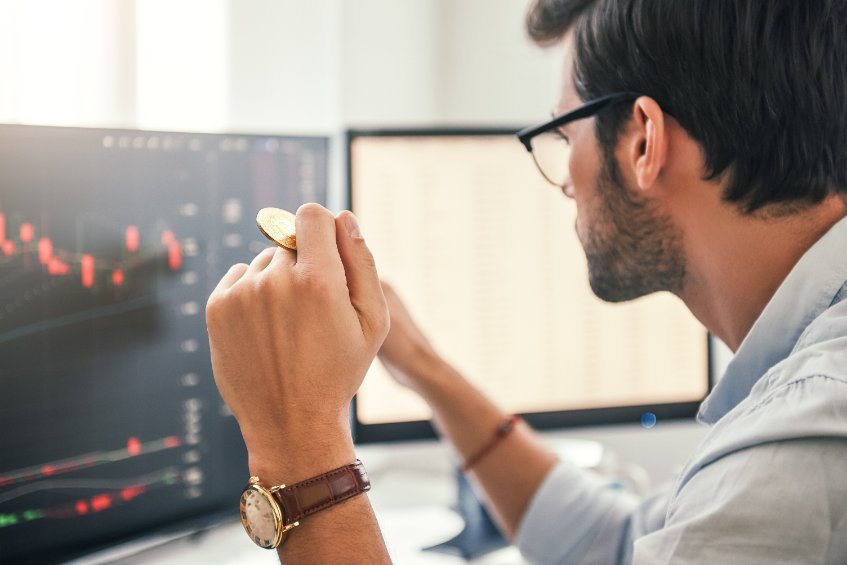 Man looking at cryptocurrency charts on monitor
