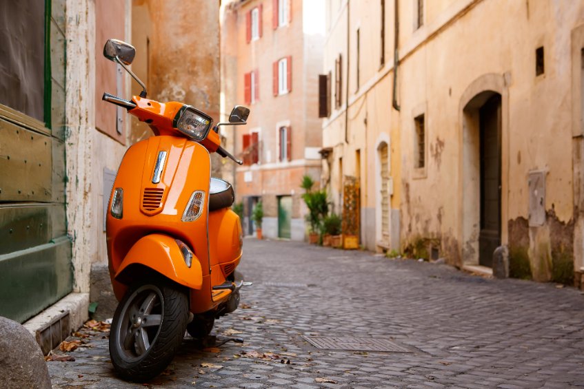 Old city street with motorbike in rome, italy. on sunny autumn or spring day.
