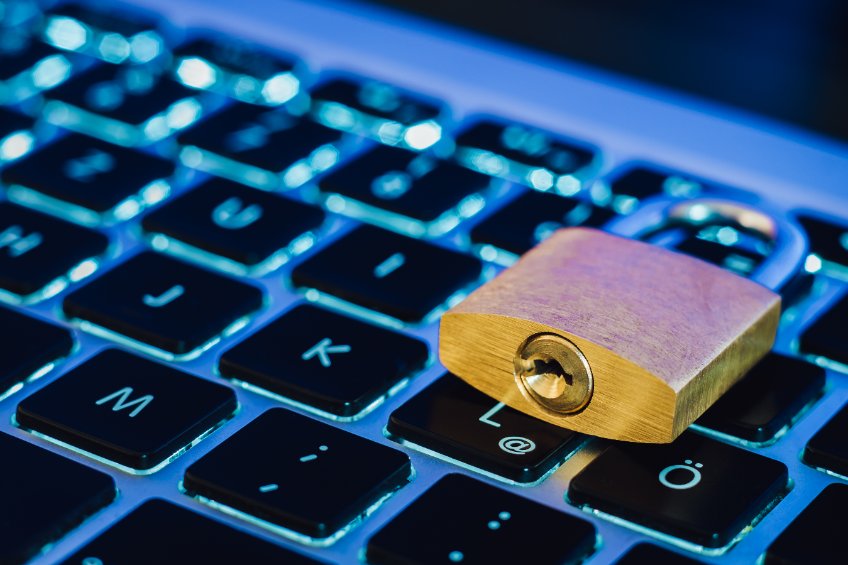 Image of a physical lock kept on top of a laptop keyboard.
