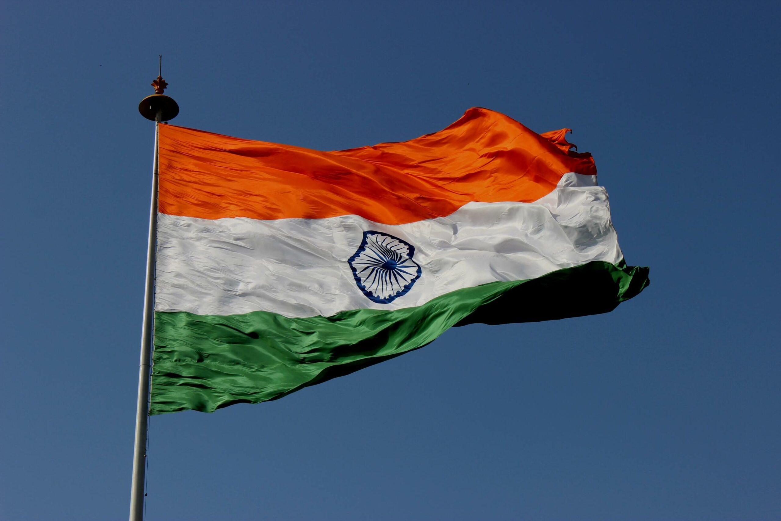 Image of Indian flag against a blue sky.