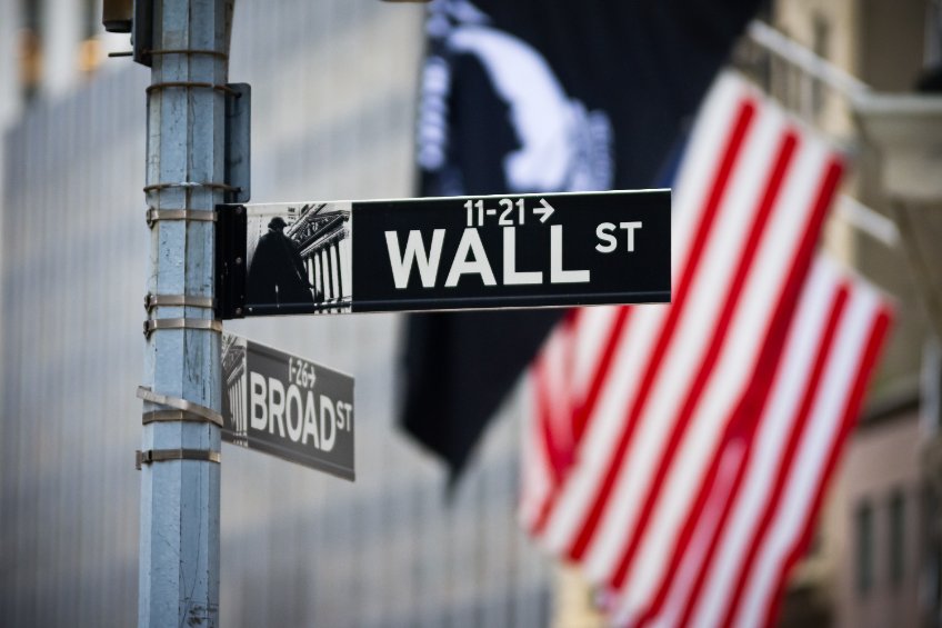 Wall street sign with american flag in the financial district of lower manhattan
