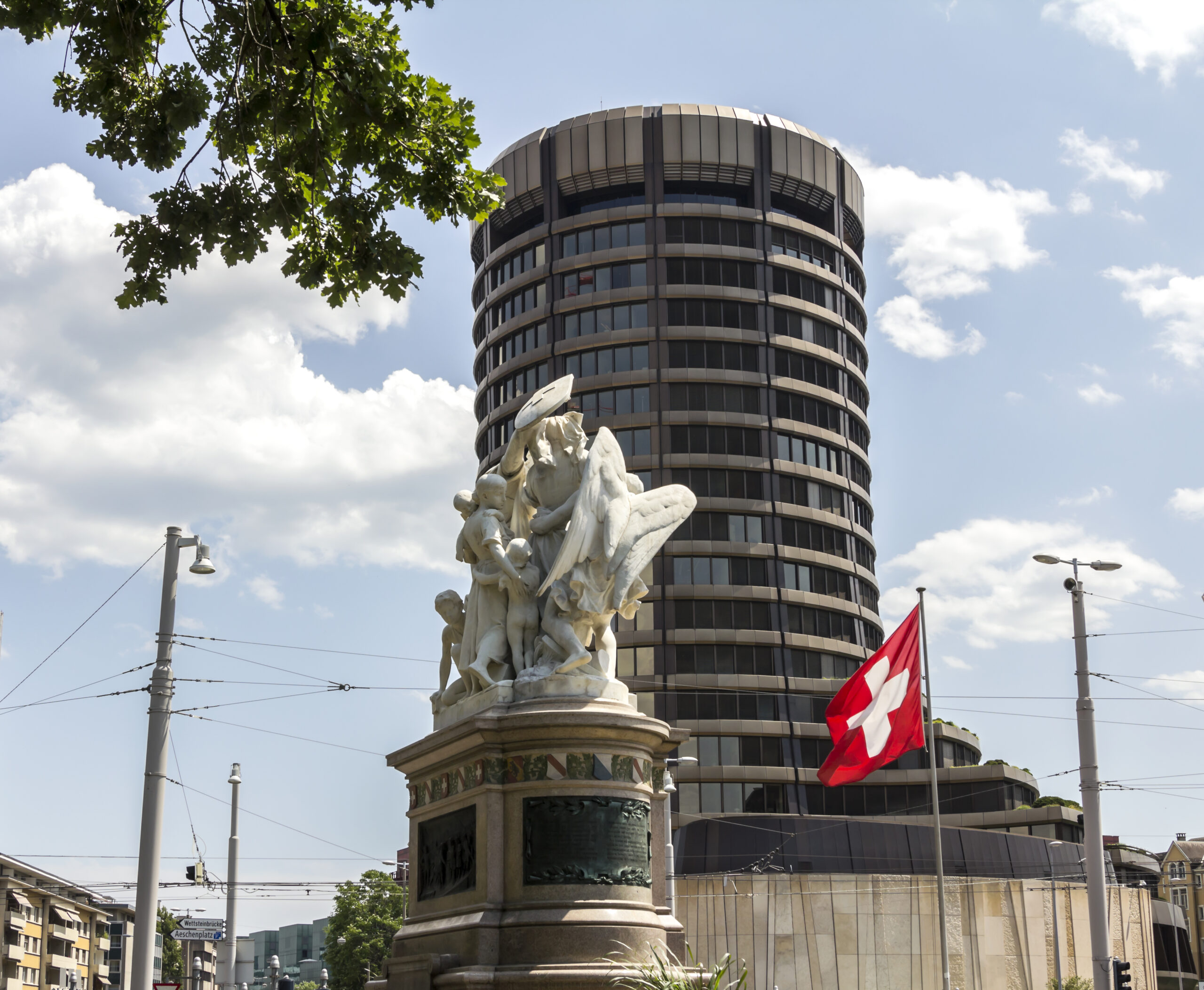Building of BIS in Basel, Switzerland with a statue in front.