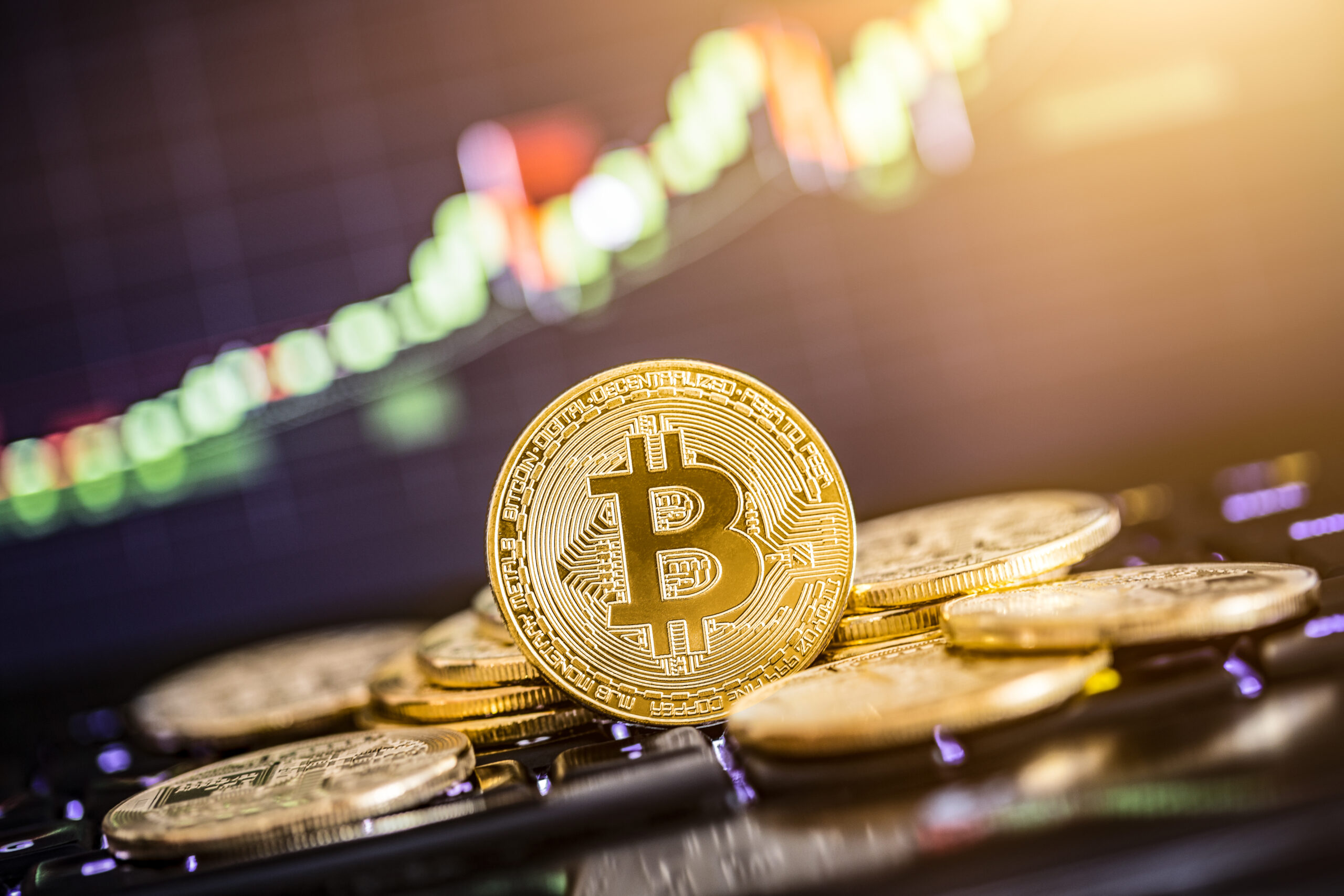 Bitcoin gold coin and defocused chart background. Virtual cryptocurrency concept.