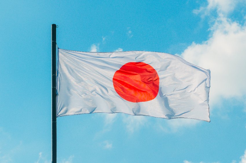 Waving colorful japan flag on blue sky