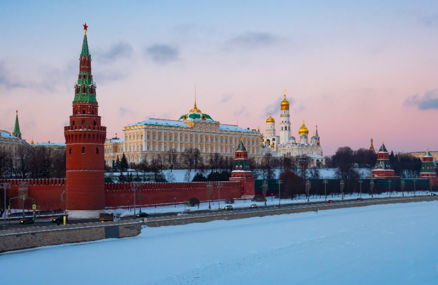 Moscow Kremlin on bank of snow covered Moskva River at sunset