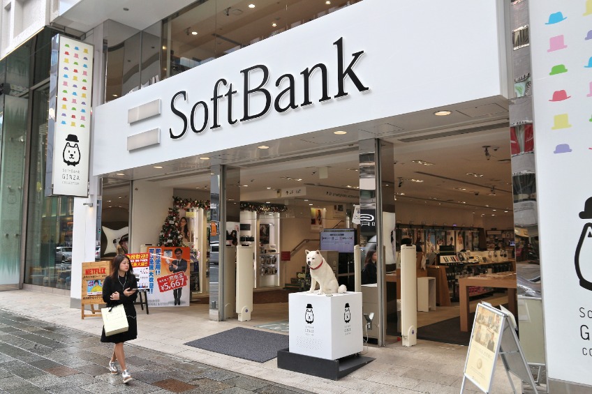 Person walks by SoftBank mobile phone network shop in Tokyo, Japan