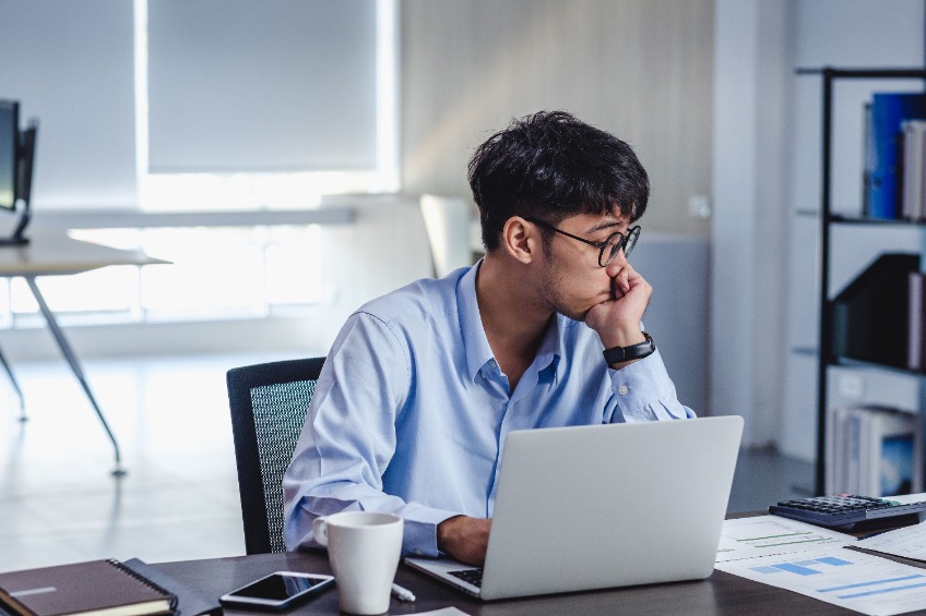 asian businessman get stress and thinking when working with laptop on desk at modern office
