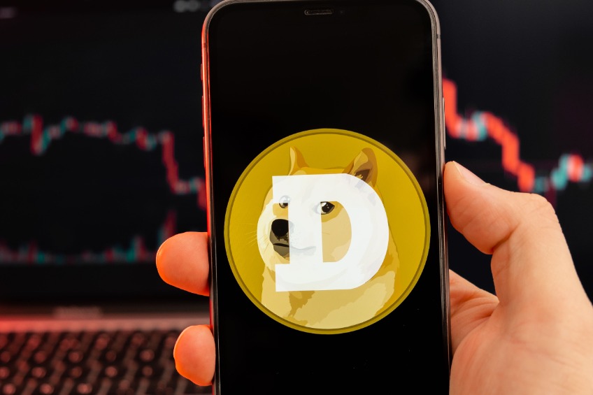 Dogecoin DOGE app of cryptocurrency stock market analysis on the screen of mobile phone in man hands