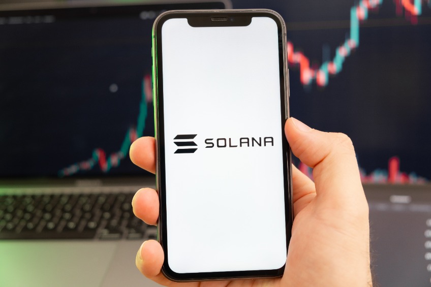 Solana SOL cryptocurrency logo on the screen of a smartphone in mans hand