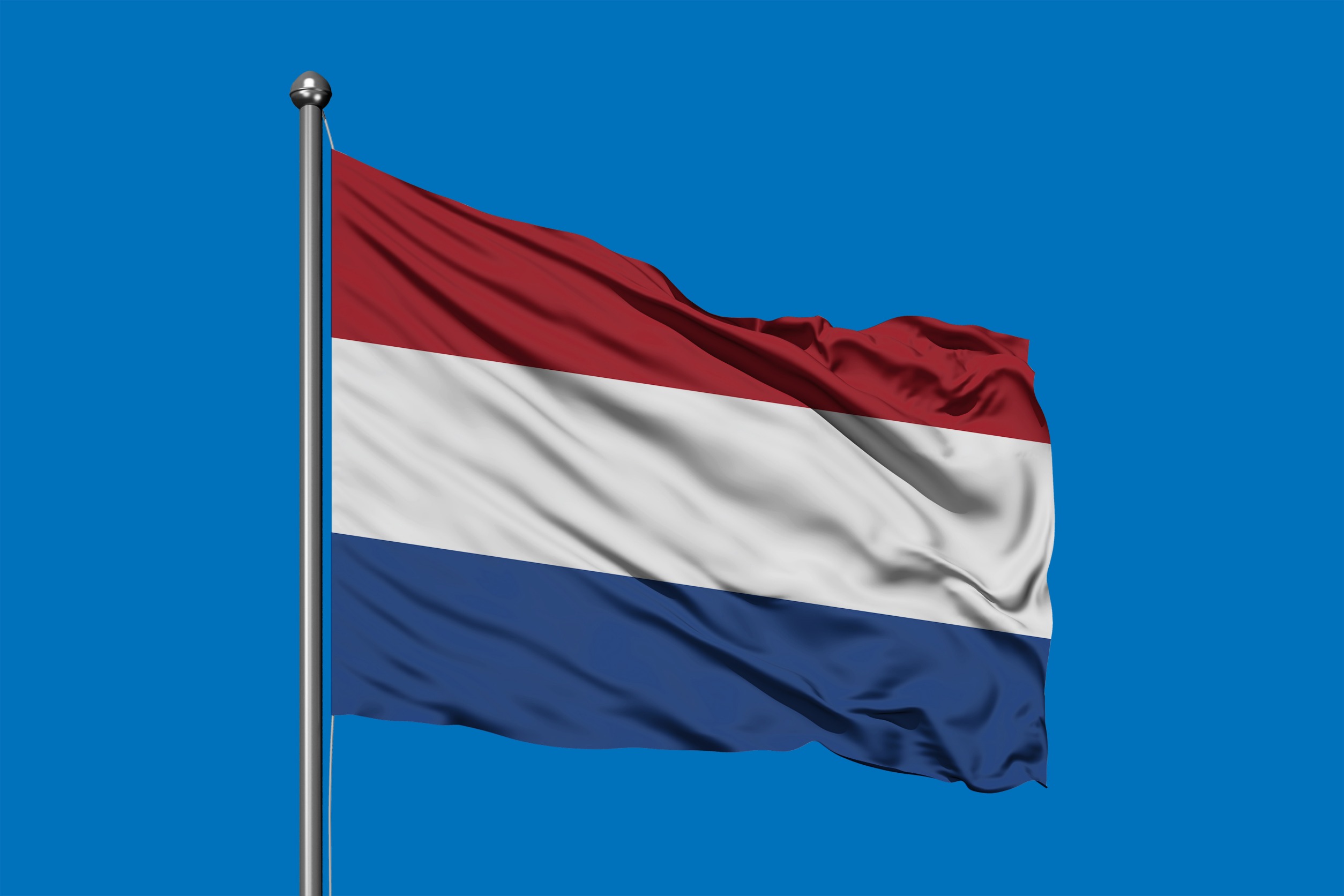 Flag of Netherlands waving in the wind against deep blue sky. Dutch flag.