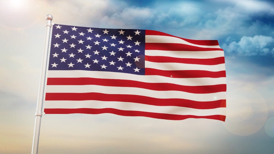 United States Flag Waving in the Air in the daylight sky.