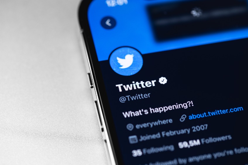 Twitter official verified account, mobile app on screen smartphone, iPhone macro.