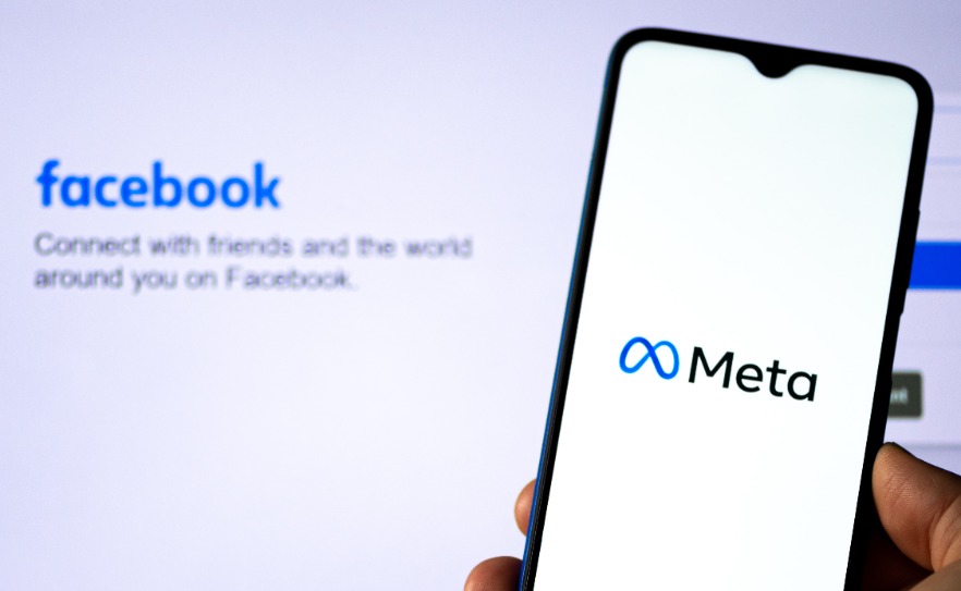 Meta Platform on the smartphone with Facebook home page on background