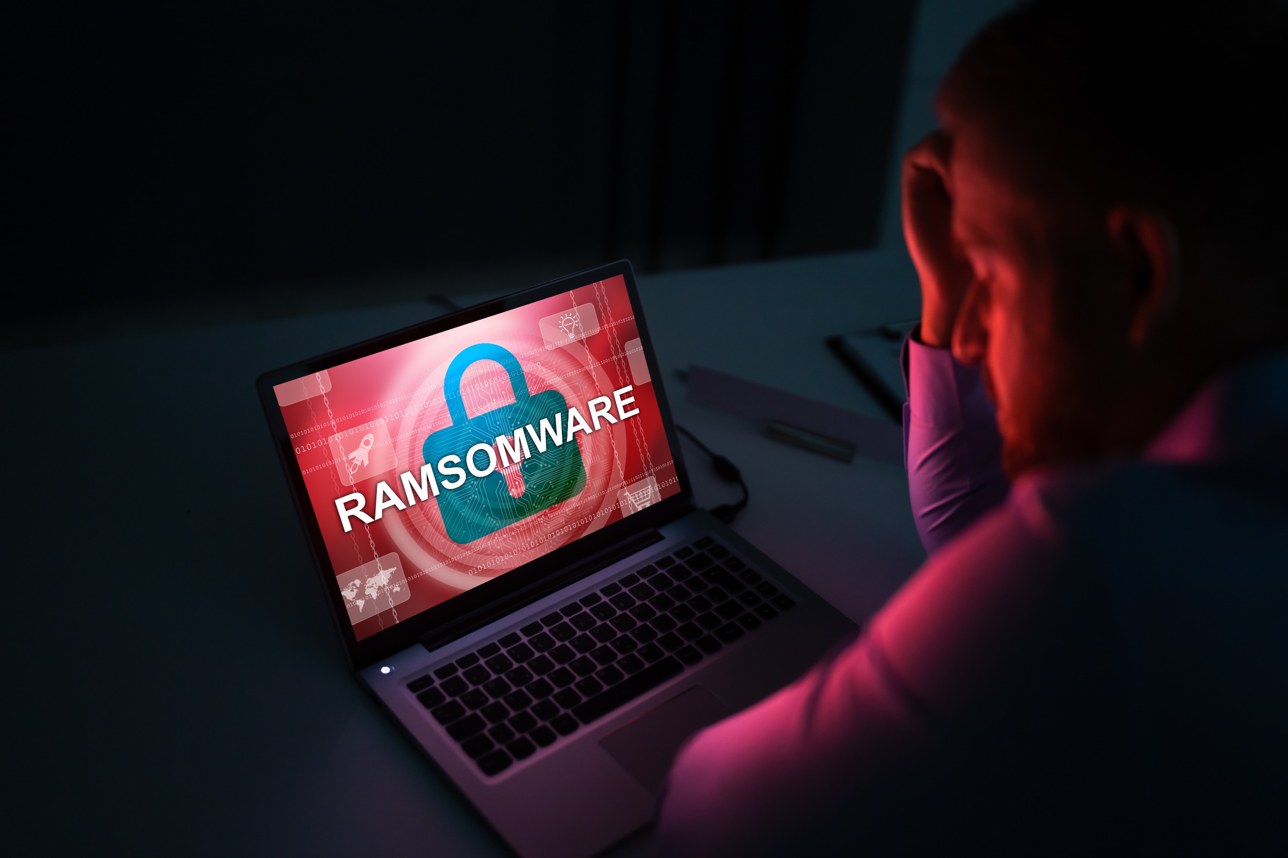 Worried Businessman Looking At Laptop With Ransomware Word On The Screen At The Workplace
