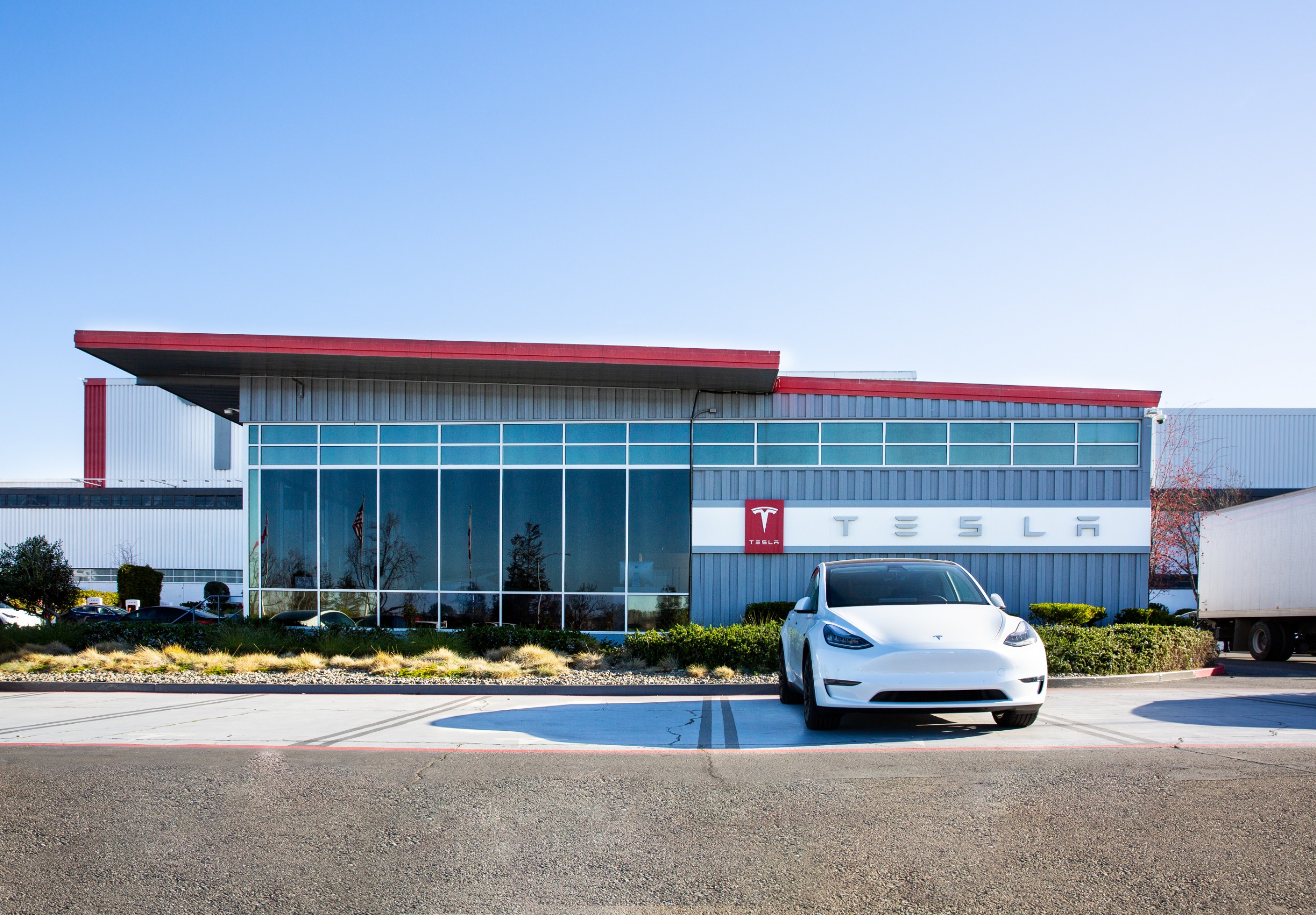 A Tesla parked in front of a Tesla building.