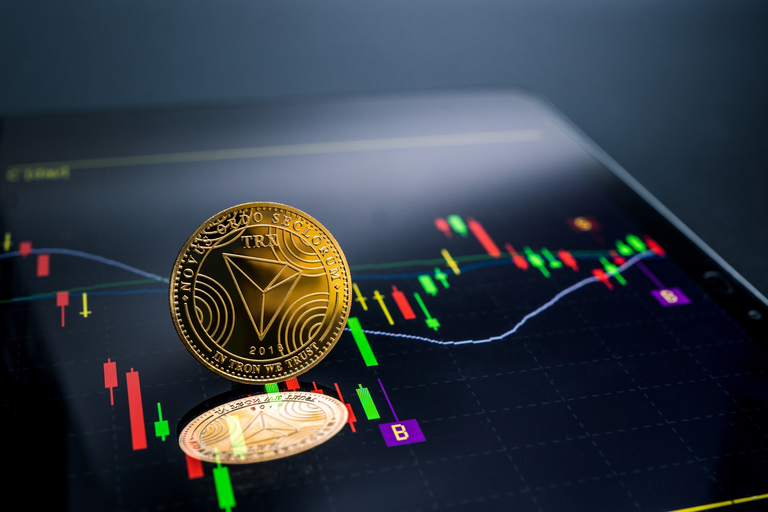 "TRON" on a phone screen showing a price chart.
