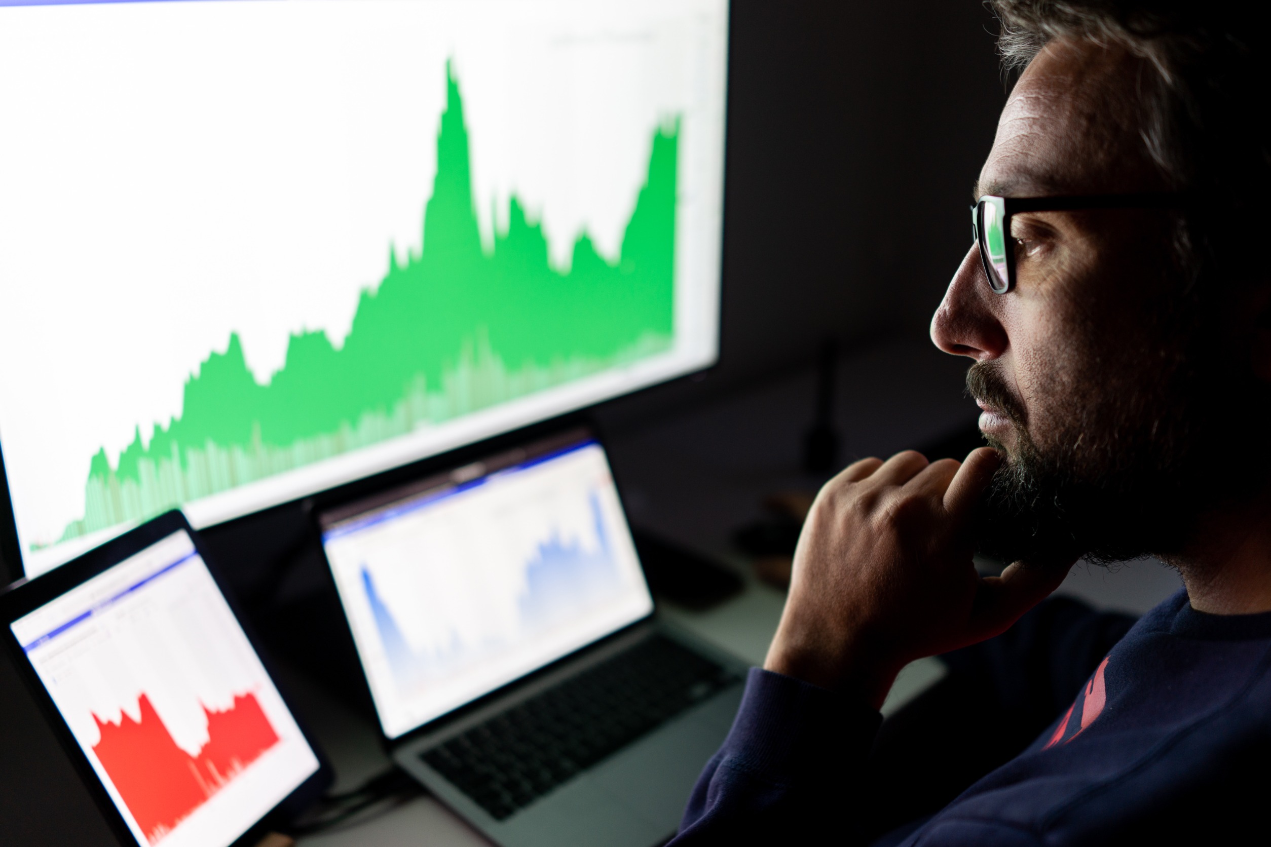 Crypto trader investor analyst looking at screen analyzing financial graph data on pc monitor
