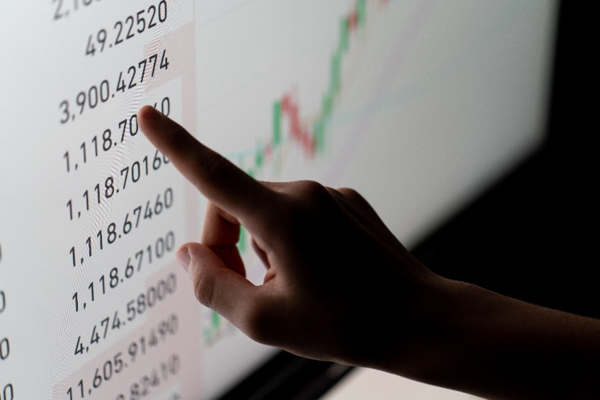 Crypto trader investor analyst looking at computer screen analyzing financial graph data on pc monitor