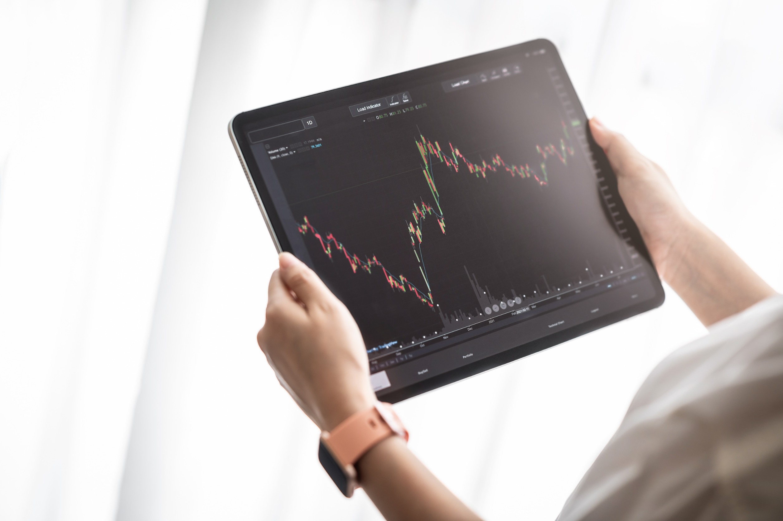 Hand holding digital tablet display stock market data with graph and chart for analyze