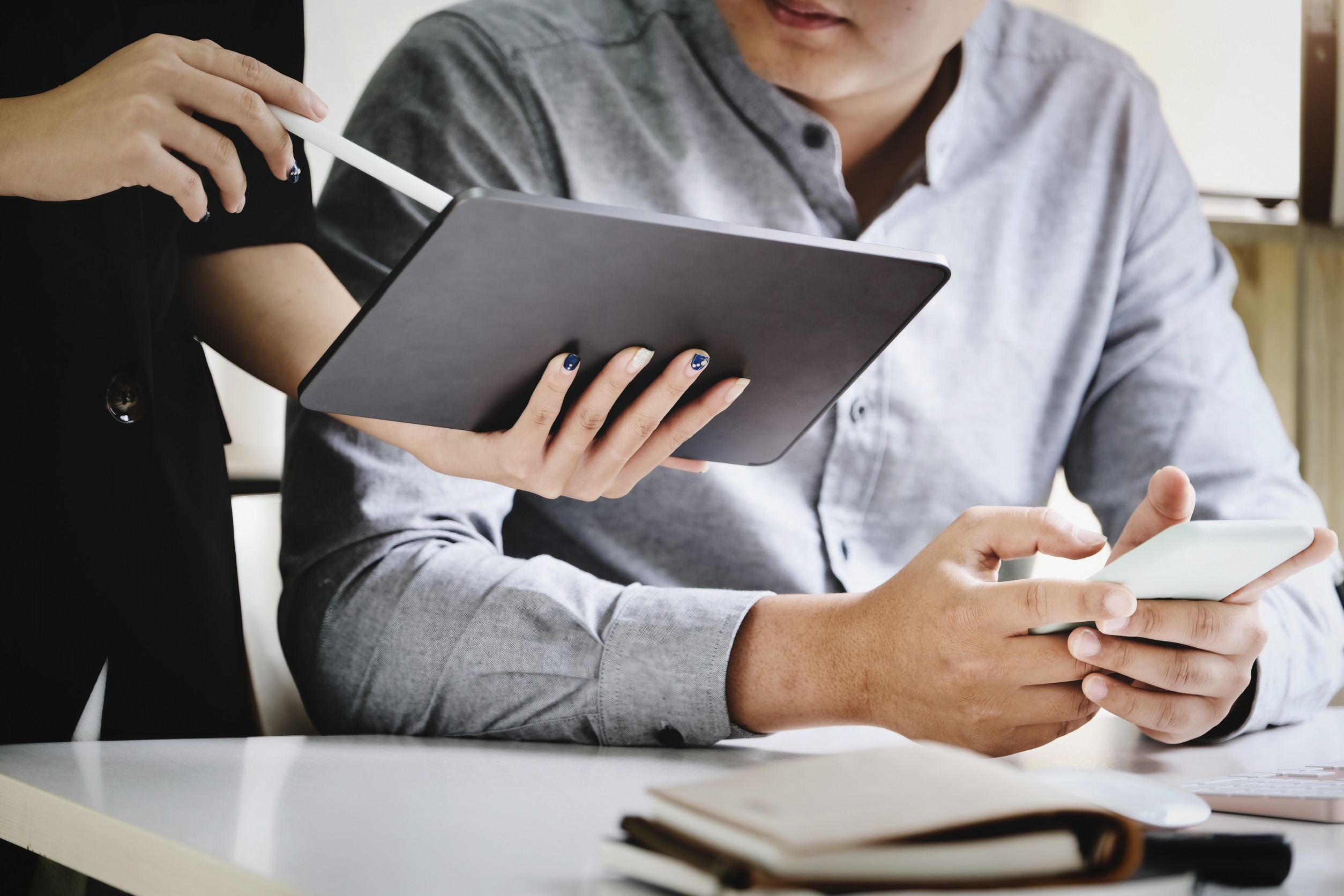 Businessman being shown something on a tablet.