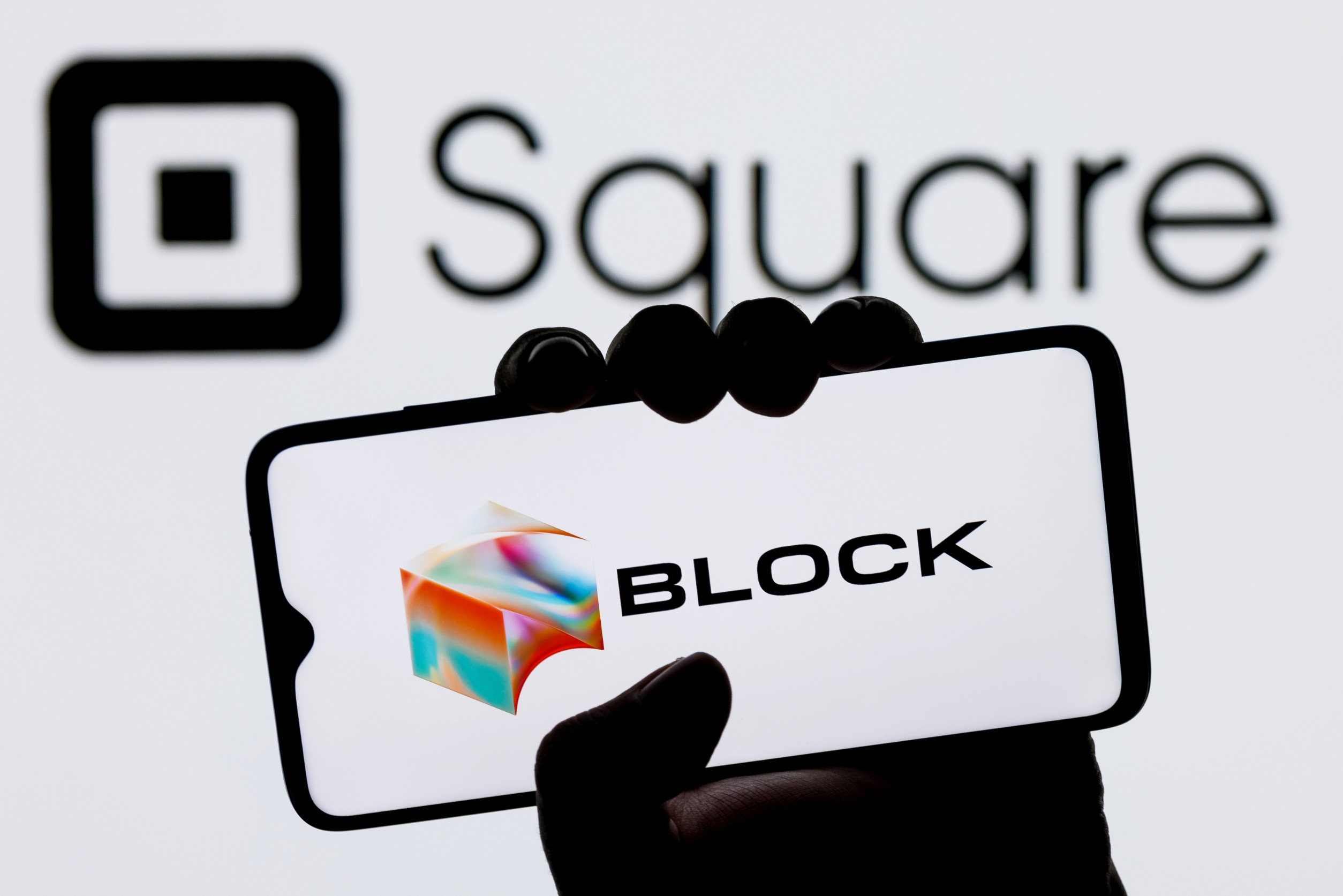 Phone Displaying "BLOCK" in front of a wall with "Square" written on it
