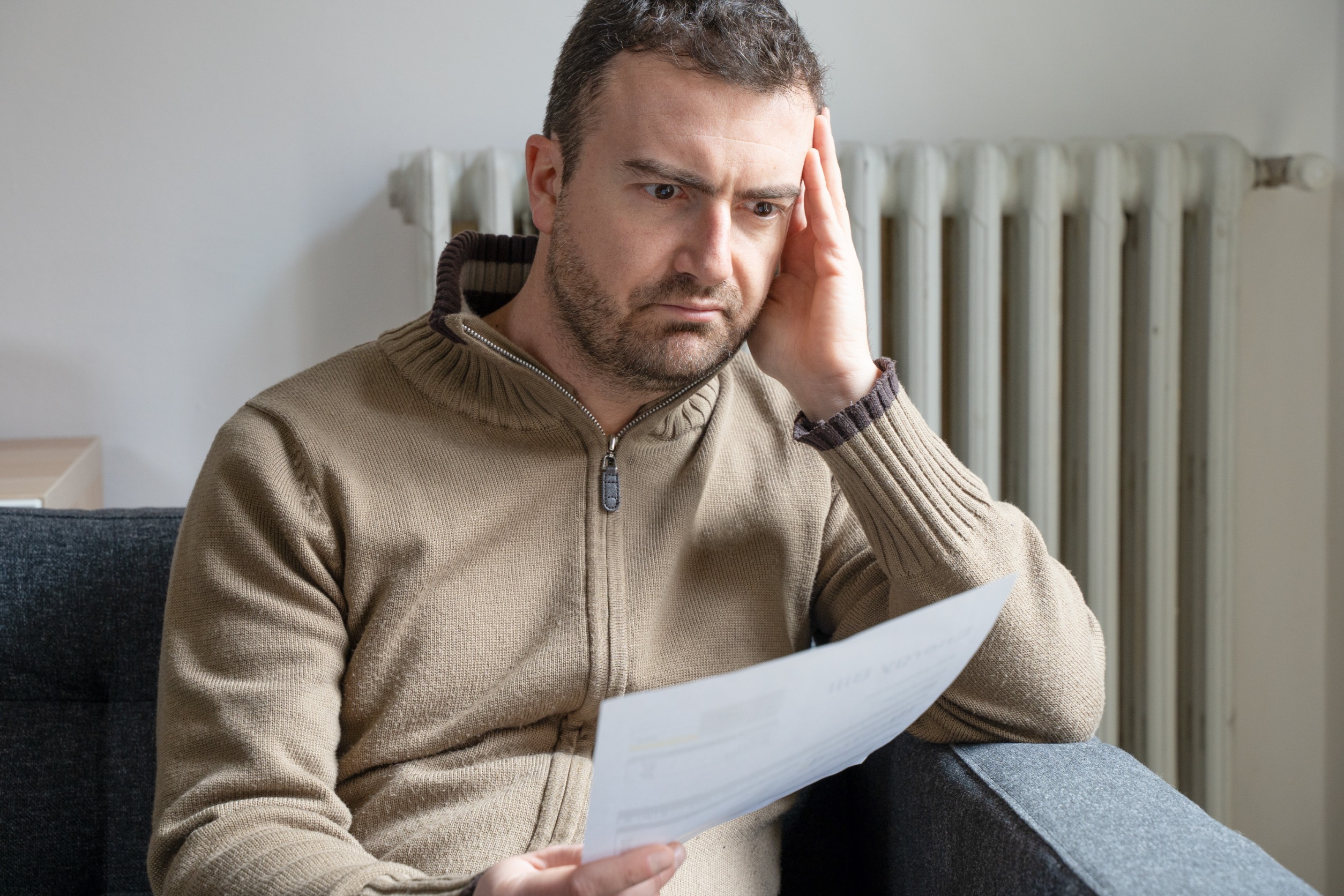 A despondent man looking at a piece of paper.