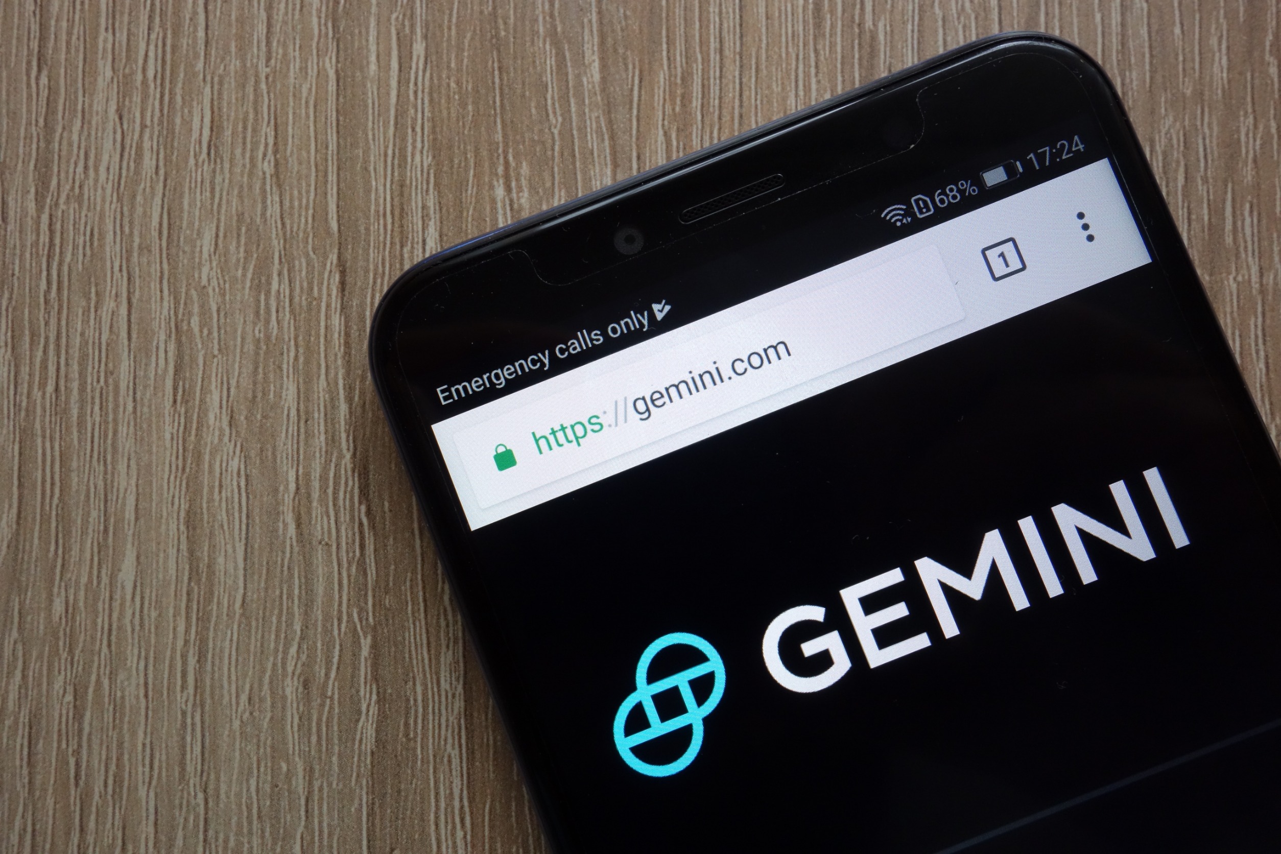A smartphone on a desk displaying "Gemini"