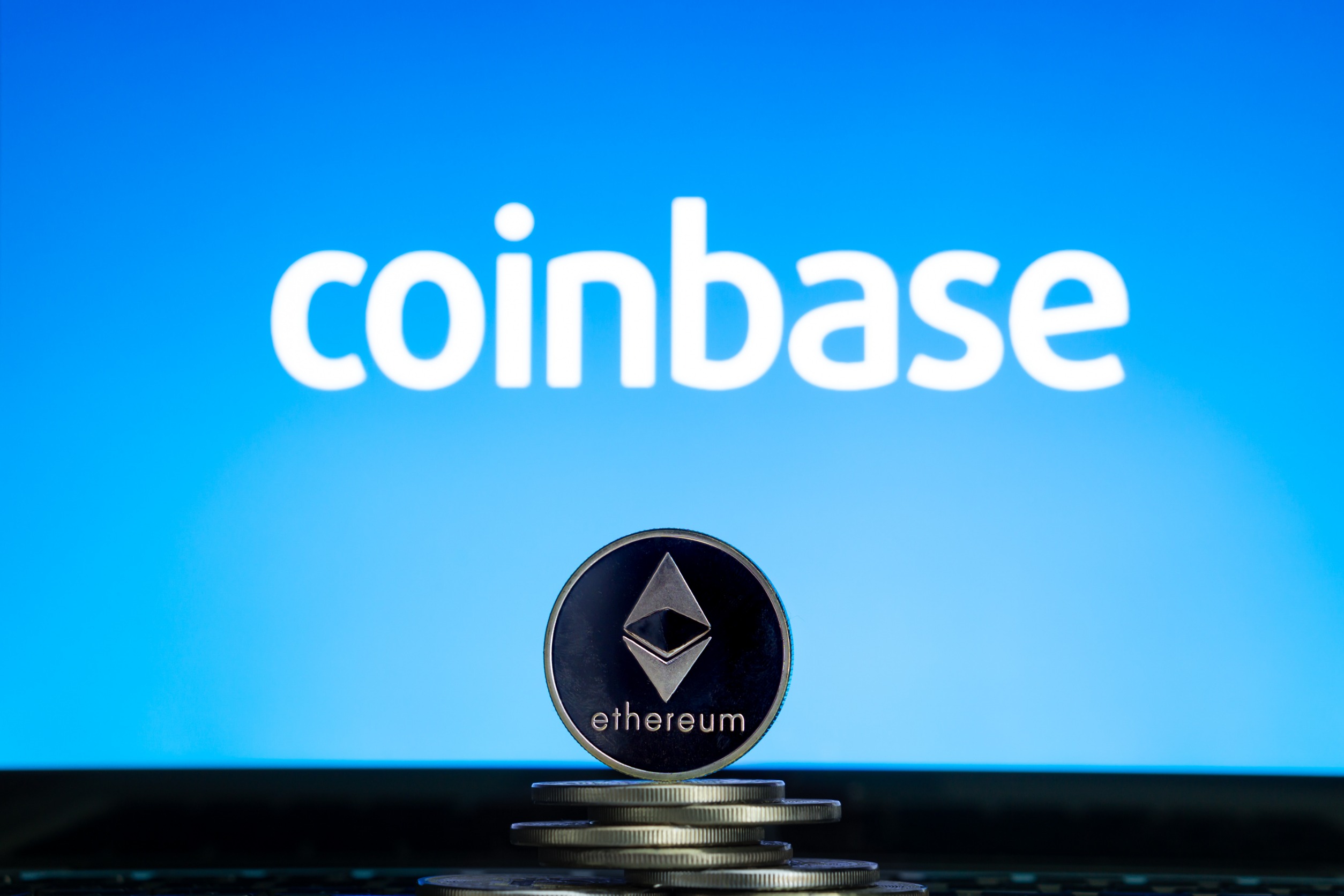 An ETH "coin" in front of a blue background with "Coinbase" written on it