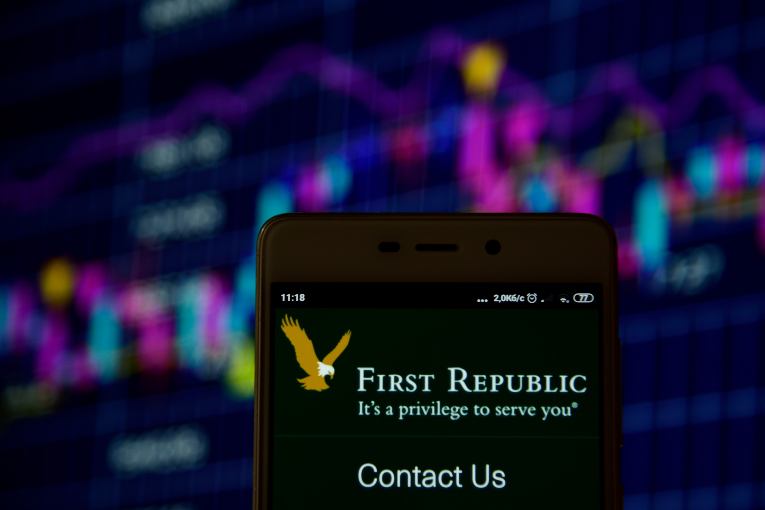 Smartphone displaying "First Republic" and its eagle in front of a volatile price chart.