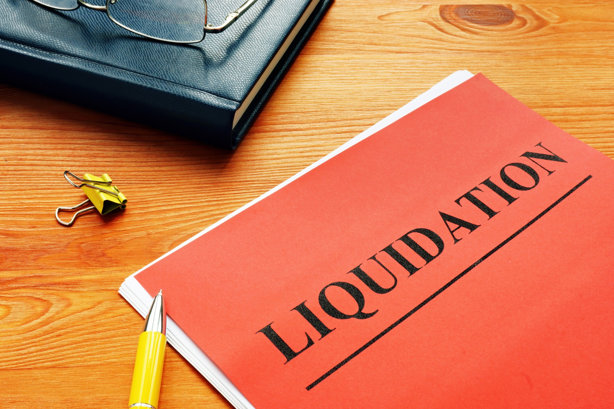 Document saying "liquidation" on a desk