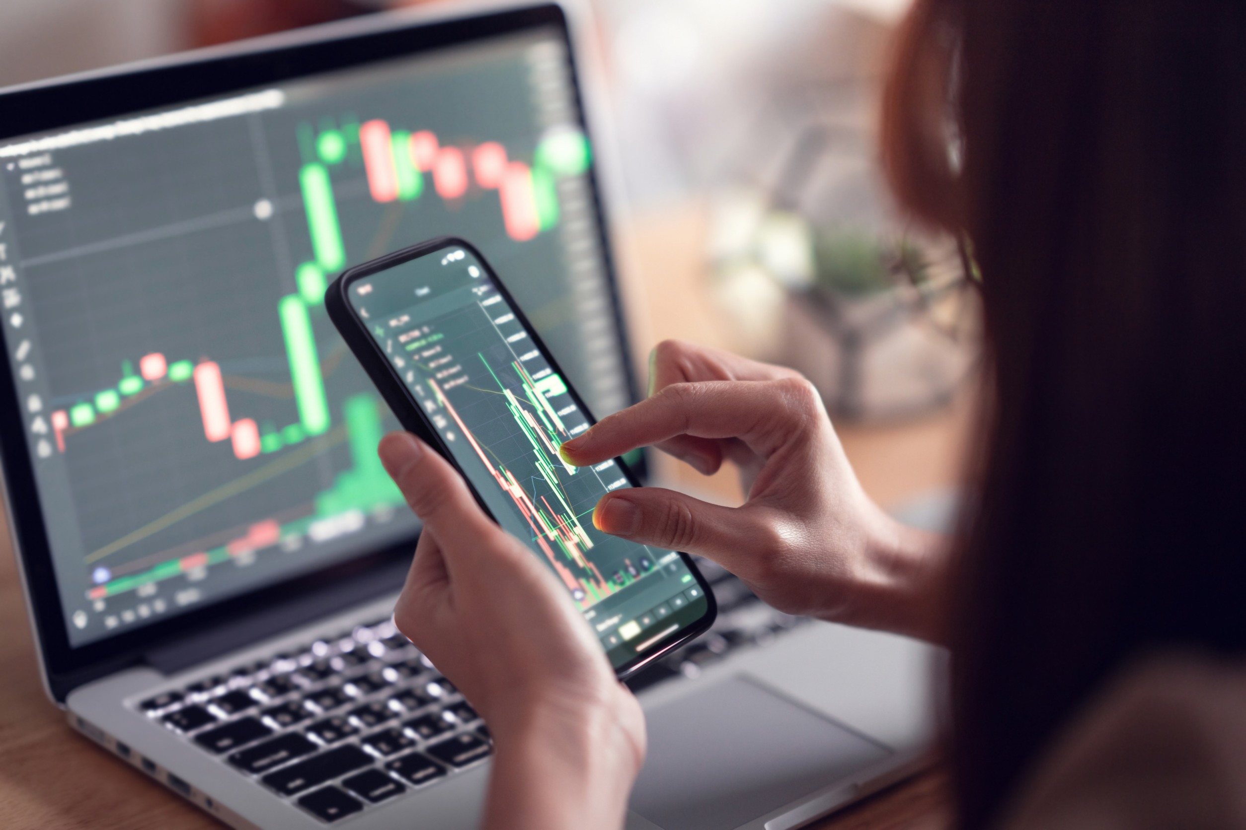 Woman is checking Bitcoin price chart on digital exchange on smartphone