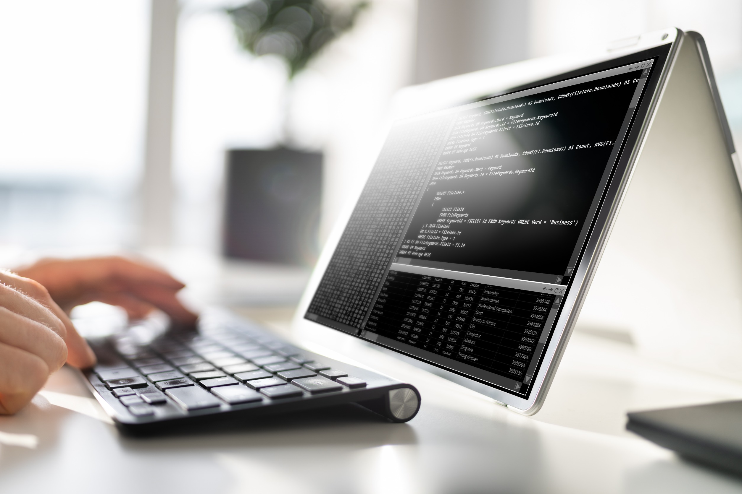 Hands writing code on a computer