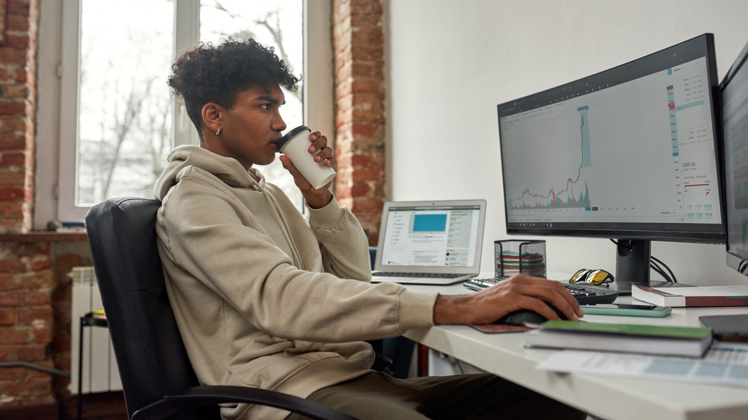 Retail crypto trader sitting at a desk and remaining optimistic about the future of crypto.