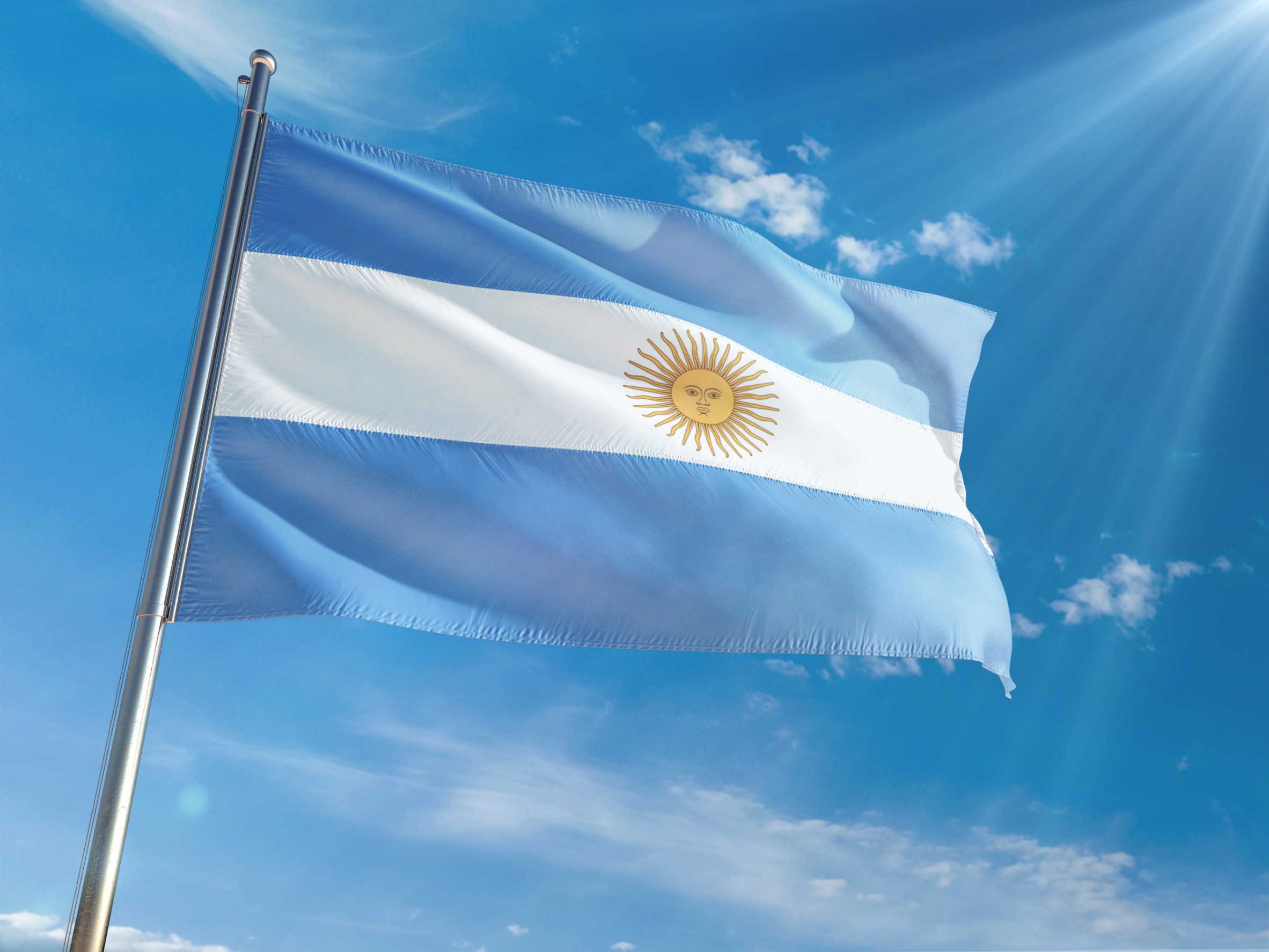 Flag of Argentina against a blue sky.