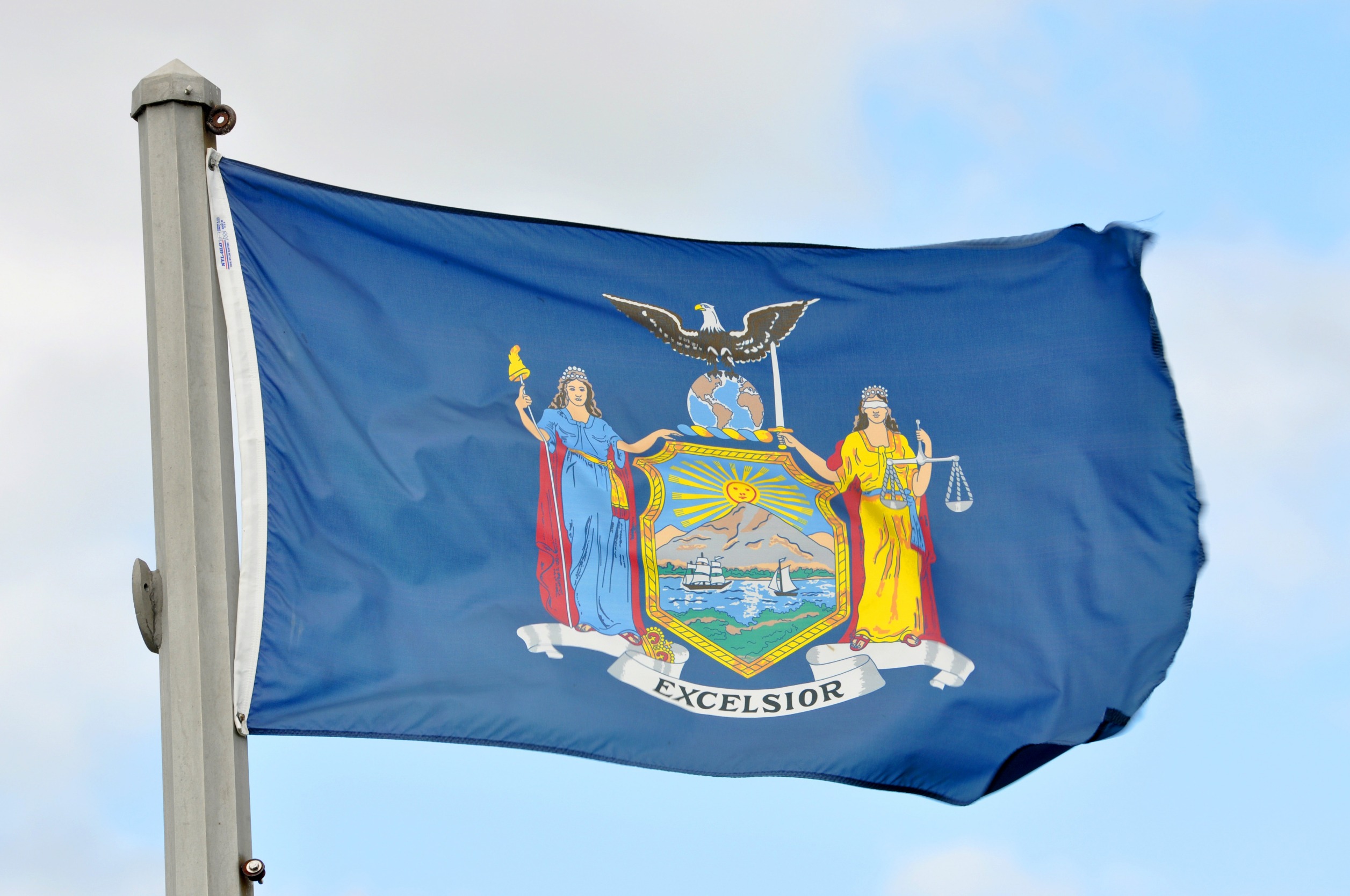 Flag of New York against a blue sky