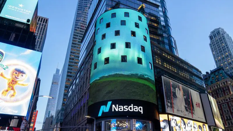 Nasdaq building in Times Square, New York City with vibrant digital display.